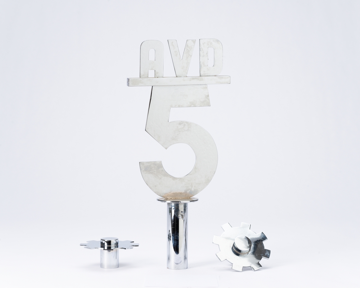 Blå fane med midtstilt motiv av skip ved kai. Rød fanekappe. Faneduken er montert på tverrstang med toppsyd og sidespyd. Bærestang.