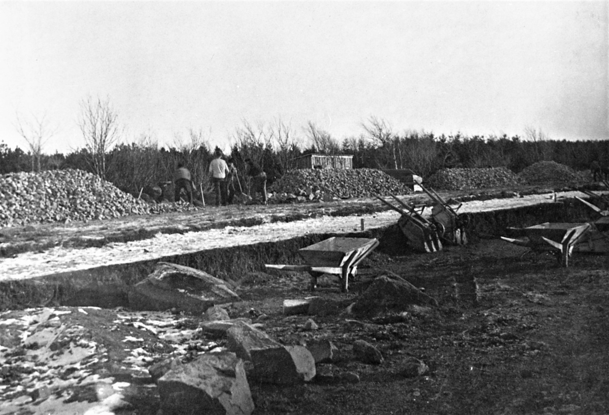 Vykort, "Varberg. Idrottsplatsen från flygplan." Flygbild över Varbergs idrottsplats, Påskbergsvallen, invigd 1925. Bortom vallen ligger Rotundan i stadens nya Nöjespark anlagd 1932. Till höger i skogen ses tak och flaggstång till Tivedstugan i Nya Påskberget. I bildens ovankant längs Påskbergsvägen ses fr v kvarteren Måsen, Fevern, Lygnern och Draen. Tranebergsgatan går igenom kvarteren och ovanför villorna ses Träslövsvägen. De korta vägstumparna mellan husen är Svanegatan till vänster och Tjädervägen till höger.

Bild nr 2: Foto från anläggande av Varbergs idrottsplats. invigd 1925. Fotograf okänd. Reprofoto av båda bilderna.