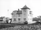 År 1903 var det pampigaste huset i Stolplyckan alldeles nyligen färdigställt och fick i folkmun namnet Gröna huset. På bilden står det i hörnet av den spåriga Djurgårdsvägen och den svårforcerade Djurgårdsgränd. Gatorna fick senare namnet Djurgårdsgatan och Magistratsgatan. Den sistnämnda lades igen när det moderna Stolplyckan växte fram runt 1980.