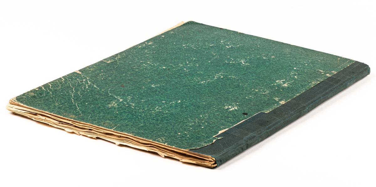 Bok med gröna pärmar och svart rygg. Innehåller en samling etiketter, främst från Gävleföretag, 1886.