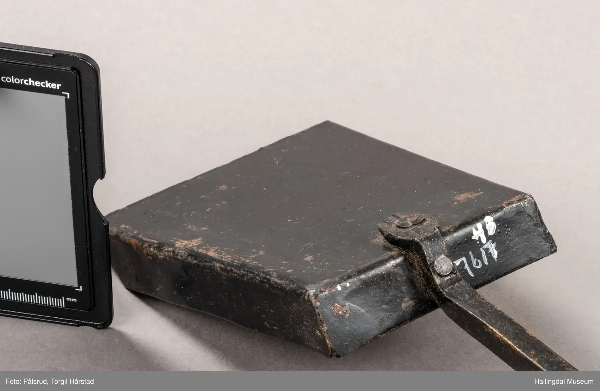 En pesspade eller askespade i smijern med vridd håndtak med ring i enden.