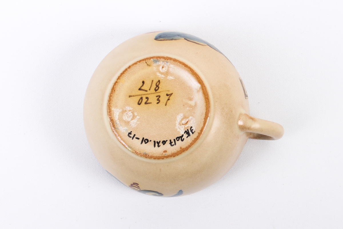 Kopp fra Graveren med dekor inspirert fra rosemaling.
