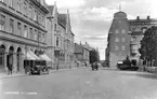 Sankt Larsgatan i Linköping med vy norrut från Landskyrkotorget. Odaterad bild från omkring 1930, en tid då ännu bilar och hästskjutsar självklart delade gatornas utrymme.