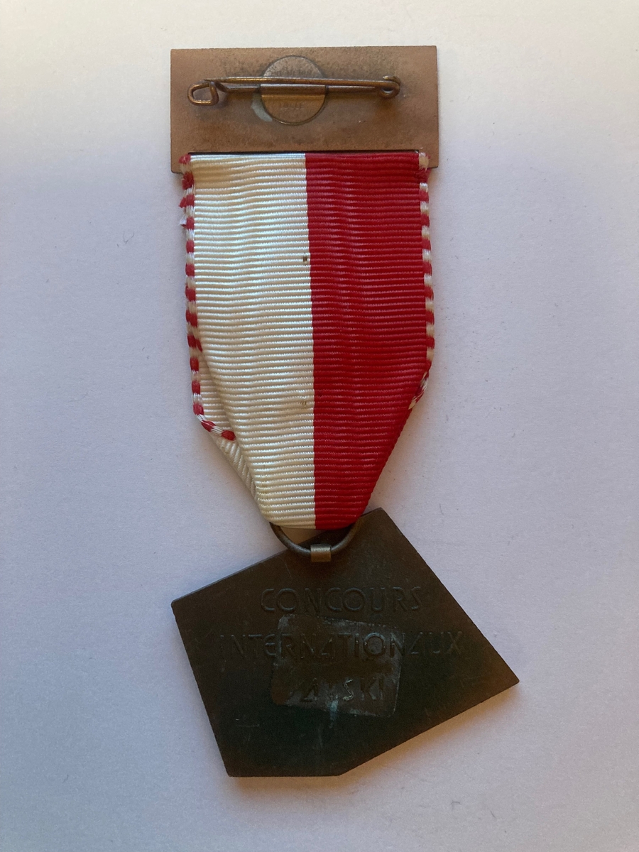 Forsiden av medaljen består av ett par ski med staver til venstre. På høyre side er det avbildet våpenet til kantonen Uri i Sveits med "Andermatt 1965" skrevet under. Våpenet er gult med et oksehode i midten. 