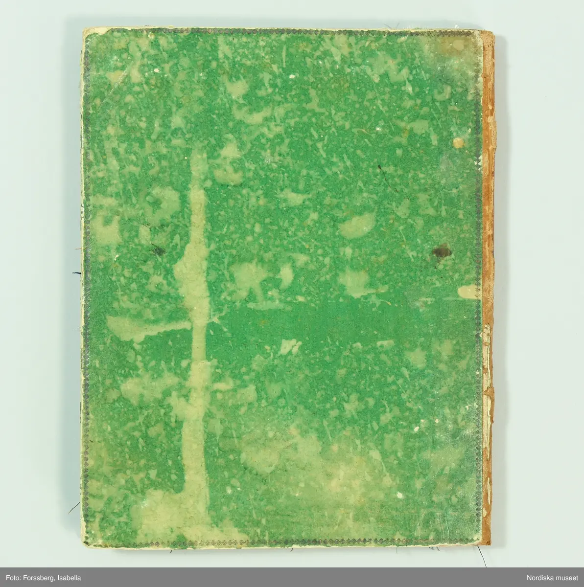 Inbunden bok med gröna pärmar och brun skinnrygg. Innehåller  11 sidor med  267 inklistrade tygprover, daterade från 1824-1858. Det är prov på främst klänningstyger använda  av kvinnorna i familjen Roos af Hjelmsäter bosatta på Rosenbergs malmgård vid Hornskroken i Stockholm, sannolikt mest från  Jeanette Wilhelmina f. 1808, gift 1843 och död 1863 . Proverna är grupperade kronologiskt, klistrade eller fastsatta med rött lack. Det är en blandning av hemvävda bomulls- och halvlinnetyger, smårutiga eller med smala mönstrade bårder av den typ som var modernt under 1820-30-talet, och bomullsripstyger med mönstrade blombårder i silke, ofta kallade västtyger, samt småmönstrade sidentyger sannolikt fabriksvävda.
68 sidenprover, 27 halvsiden, 1 tryckt siden, 64 bomullstyger, 62 tryckt bomull, 1 bolstervarstyg, bomull, 17 halvylle, 14 tryckt helylle, 2 helylle, 5 tryckt halvylle 1 linneprov, 1 sammetsprov.
 Från 1824 finns ett vitt sk. sticktyg i bomull som är en importvara. Redan bland de första sidorna från 1820-talet finns flera maskintryckta bomullstyger, vilket återkommer från varje tid och visar hur modet för tygtryck förändrades. Från 1825 och 1828 finns en mängd sidentyger  med småfiguriga mönster en del antagligen jacquardvävda. 1828 finns även en typ av tunna mönstervävda ylletyger med tryckta blommönster. 1833 prover på tunn yllemuslin med tryckta blommönster. Samt 2 prover på vita tunna maskinvävda bomullsmusliner av den typ som sannolikt importerades från England och Skottland och började spridas just kring 1830. Från 1840-talet finns inga prover.  Från 1856 finns flera jacquardvävda sidentyger och tryckta yllemusliner på både vit, svart och ljusgrön botten, dessutom enfärgade släta redgarnsylletyger från 1850-talet . Längst bak i boken skrivet: "Små profver å tyger begagnade i familjen från år 1824 till 1858.  Sophie Lagerberg" . Hon var född 1846, dotter till Jeanette Wilhelmina Roos af Hjelmsäter som tillsammans med maken Carl Julius Lagerberg var bosatt på Rörstrands porslinsfabriks område där han var anställd. Tygerna bör alltså vara prover på vad en välbärgad stockholmskvinna hade i sin garderob.
I boken finns även inklistat en vävnota med tillhörande tygprov på ett bomullstyg i tuskaft med små stiliserade blombårder vävda på 8 skaft och 5 trampor. Påskrift: Arbetat af J.W. Roos af Hjelmsäter på 1820-talet. Detta prov och flera av de andra tidiga i boken hör till den sort som lärdes ut av familjen Ekenmark på deras vävkurser på 1820-talet. Sannolikt hade Jeanette Wilhelmina deltagit i en sådan, och hon ägde också ett ex. av Ekenmarks Wäfmönsterbok. prover i boken finns  på "engelskt klädningstyg med bård af wäfda weck och faconer, stjerntyg på tvären samt mönsterbårderna nr 22, 23, 27, 35 och 37 1/2 i Mönsterbok för Unga Fruntimmer av M.C Ekenmark, samt mönstren 44, 46, 50, 51, 52 i Wäfmönsterboken. 
Att det inte finns några prover från 1840-talet kan bero på att hon då var nygift och hade småbarn och kanhända inte hann med längre. Längst bak i boken har hon klistrat in en vers hon fått av sin egen mor Sofia Gustafva RaH född Bratt från Sunne i Värmland julafton 1824:"Var glad och lycklig nu/ Din glädje tid är när:/ haf Gud i minne Du/ så blir han dig alltid kär./Gud gif dig alt gått och all god hälsa/ så wet jag att jag har bjudit til/ att skaffa dig all lärdom som i/ en god mors magt har stått/ och kom alltid ihåg hvad/ jag har med all godhet lärt dig. /Mamma d. 24 dec. 1824.
Jfr med tygprovsamling 91.897
/Berit Eldvik 2011-02-03