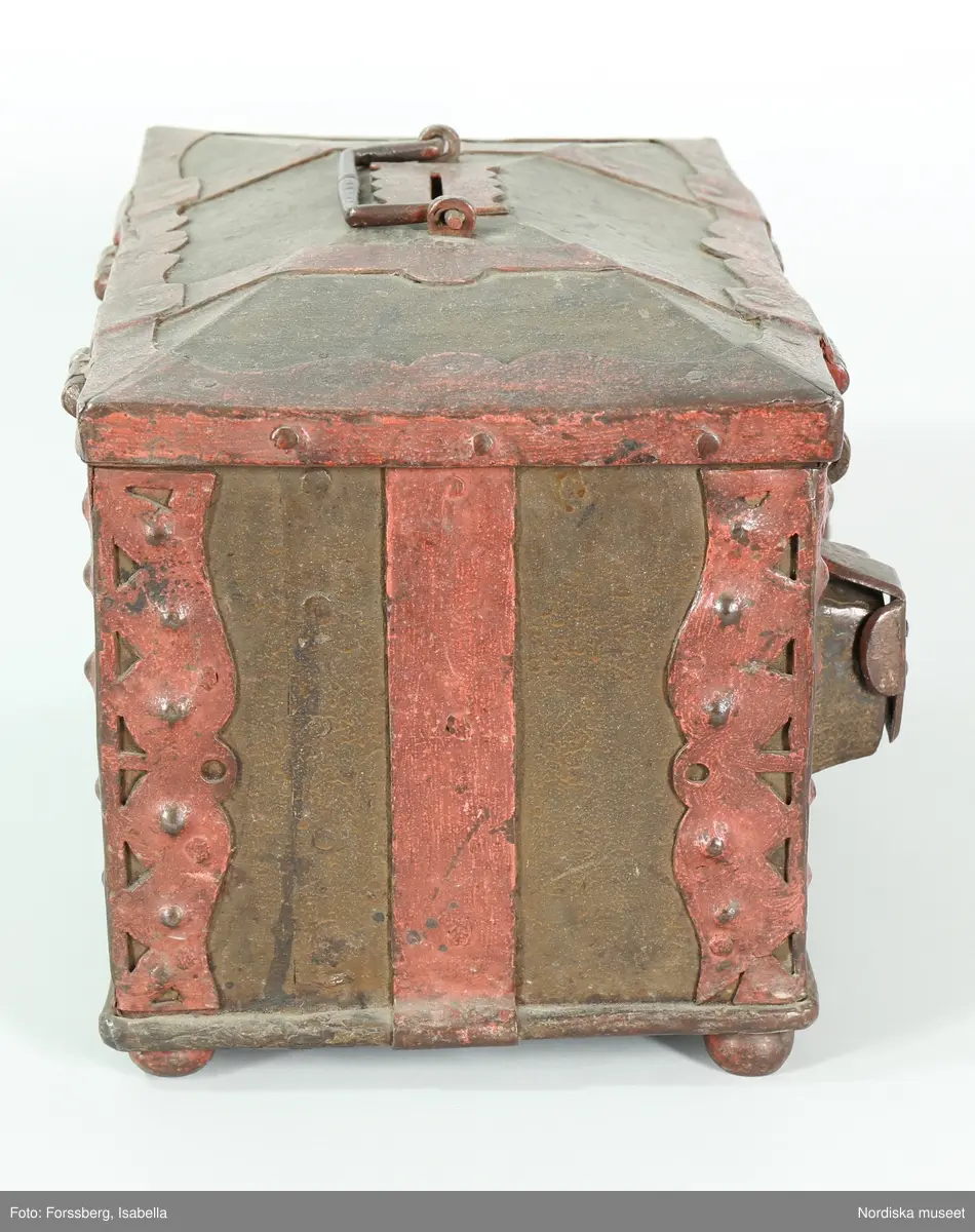 Huvudliggaren;
"a-c, Skrin, som tillh. hovslagarämbetet i Stockholm, dat. 1623. Av järnplåt m. rödmålade beslag och 2 nycklar; rekt. med fällock. fr. hovslagarämbetet i Stockholm 1868. 
a) skrin, b) nyckel (L 9 cm), c) nyckel (L 7,8 cm). 
Från Statens historiska museum 1925.

Inventering Sesam 1997-1998:
B 31, Djup 23, H 23 cm
Skrin (a), rektangulärt, med kupigt fällock, av järnplåt. Järnband fästade runt botten. Järnplåtarna ihopsatta med nitar på gavlarna.
Beslag med utstansad dekor runt hörnen.
Fasat lock med beslag runt kanterna, två bandgångjärn fästade på utsidan samt med gångjärn även vid framkanten där två låshaspar sitter.
Två utanpåliggande lås på framsidan, låses med låshasparna samt nycklar som nu saknas (har antagligen varit märkta b och c).
Skåra mitt på locket, att lägga mynt i, läderbit fästad runt öppningen på insidan, beslag på ovansidan.
Bygelhandtag fästat i märlor på locket.
Utvändigt målat i brunaktig färg, otydlig inskrift i svart på framsidan samt årtalet " 1623 ", beslagen målade i rött. Skrinet står på kulfötter, med rester av röd färg.
Från Hovslagarämbetet i Stockholm 1862.
Agnetha Blomberg 1998