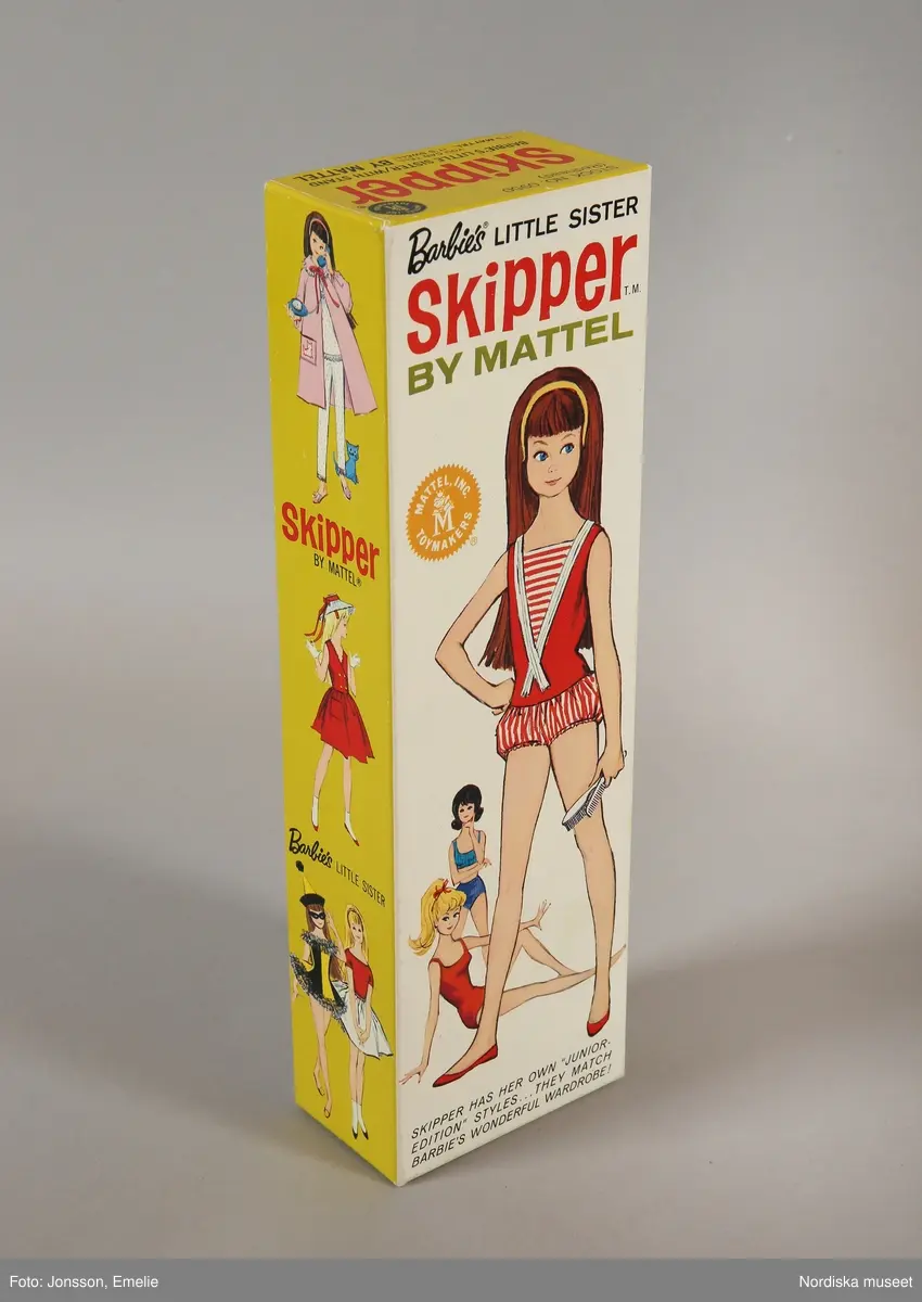 Inventering Sesam 1996-1999:
Barbiedocka, "Skipper" (a), i originalask, av plast, långt brunt hår, blå ögon. I förd röd hel sportdräkt med randiga byxor. I asken även ett par röda skor, 1 kam och en borste samt en katalog över Barbietillbehör (b). Skipper är Barbie's lillasyster. Dockan är amerikansk men tillverkad i Japan.
ELB maj 1967 /= Eva Lis Bjurman/