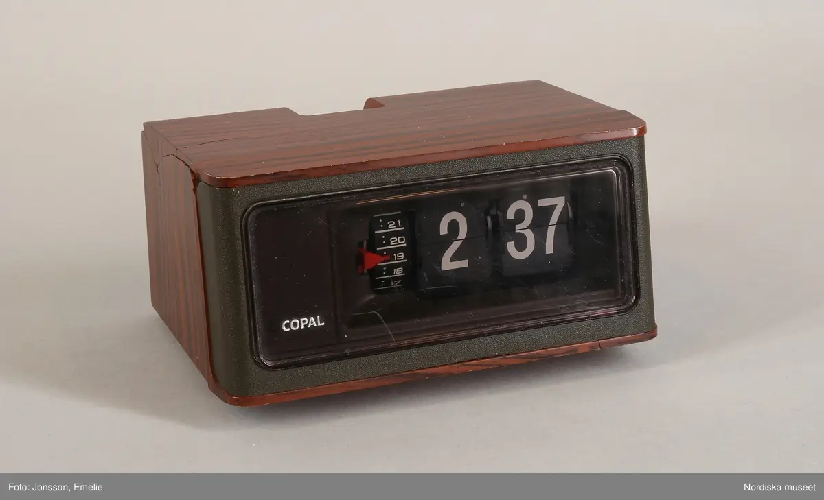 Huvudliggaren:
"Väckarklocka, elektrisk, plast. Fyrkantig, brun träimitation, rökfärgat glas, vita digitala siffror. Tillv. Copal, Japan ca 1970. gåva av anonym givare som utsatts för sexuella övergrepp som barn på 1960-70-talet, då hon kunde se klockan nattetid. H 7,5, L 14, B 10 cm. Fast sladd. Spricka på undersidan. G 29/9 2000 Anonym givare pseudonym Gertrud."

Bilaga:
"Gertruds" berättelse om klockan.