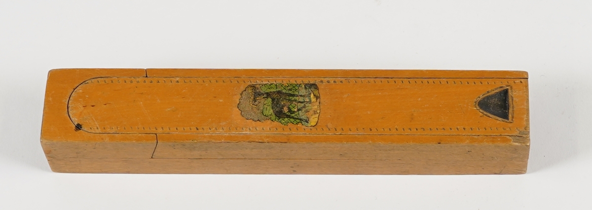 Penal med to rom. Det nedste rommet vert tilgjengeleg ved å svinge det øvste til sides. Det øvste rommet har skyvelok, og er delt i to rom. Skyveloket er avrunda i eine enden, og i den andre er det ei fordjuping som gjer det lettare å skyve loket fram og attende. Loket har stipla dekor rundt kanten, samt teikning av ein bukk midt på. I det nedste rommet ligg det to penneskaft, utan spissar. På innsida av loket er det set merke for kvar halve cm på eine langsida.