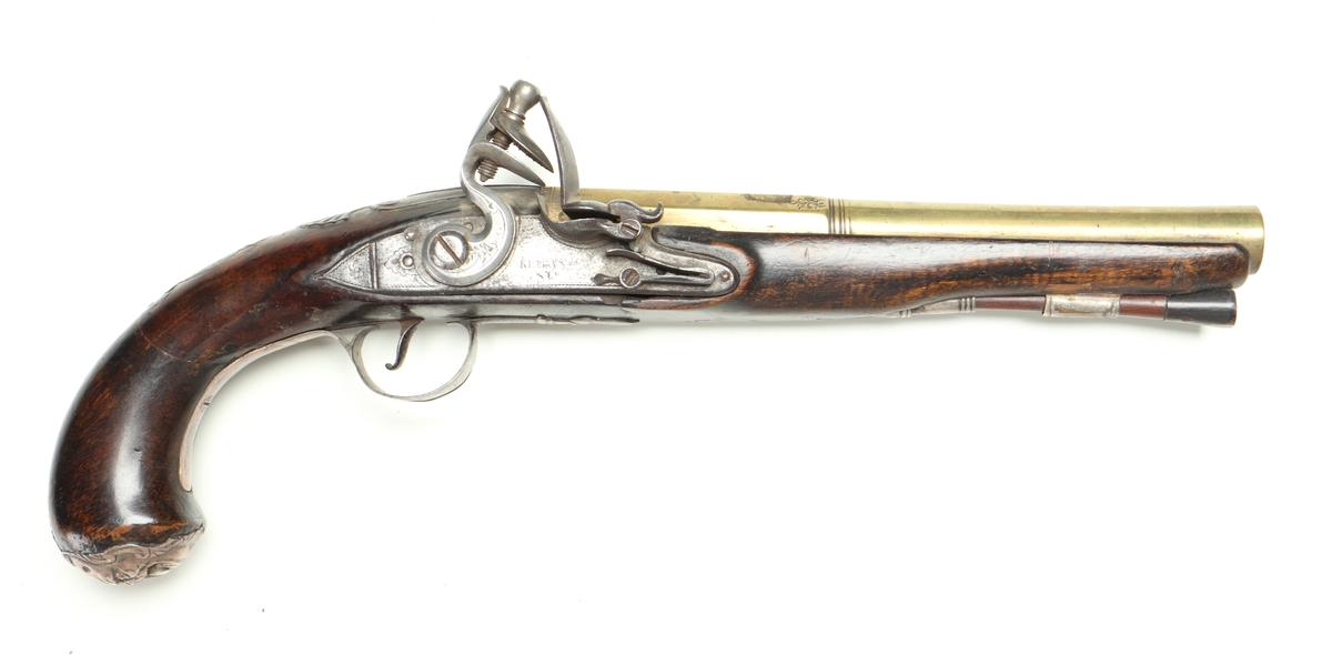 Flintlåspistol med helstock och lås i stål i s.k. Centuckystil. Pipan är gjord i mässing, och kolvkappa, varbygel, sidobleck, tumplåt och rörkor i silver. Pipan är märkt "ST-965", samt två kontrollstämplar från London, och som är åttakantig i formen, men övergår i cylindrisk form ut mot mynningen. Kolvkappan har silverstämplar från Birmingham, varbygeln likaså. Sidoblecket är utformat som blomsterslingor, och kolvkappan som en maskaron. Varbygeln är ornamenterad med en blomma i en oval. Längst fram är den utformad som ett ekollon. Tumplåten är märkt med "EC". Laddstock finns under framstocken.
Inskrivet i huvudkatalogen 1974.