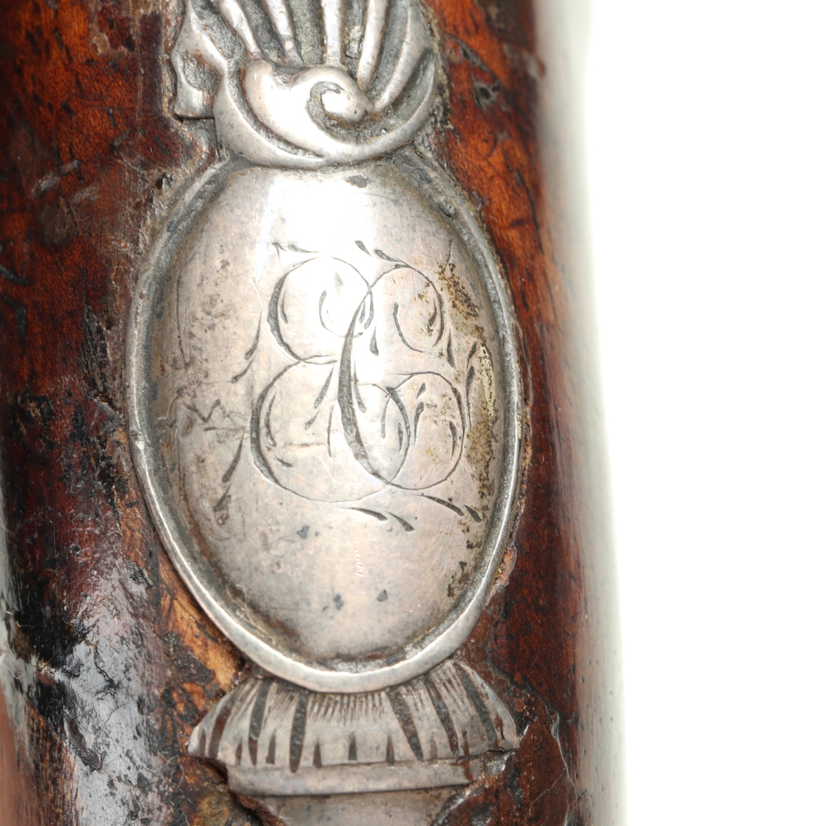 Flintlåspistol med helstock och lås i stål i s.k. Centuckystil. Pipan är gjord i mässing, och kolvkappa, varbygel, sidobleck, tumplåt och rörkor i silver. Pipan är märkt "ST-965", samt två kontrollstämplar från London, och som är åttakantig i formen, men övergår i cylindrisk form ut mot mynningen. Kolvkappan har silverstämplar från Birmingham, varbygeln likaså. Sidoblecket är utformat som blomsterslingor, och kolvkappan som en maskaron. Varbygeln är ornamenterad med en blomma i en oval. Längst fram är den utformad som ett ekollon. Tumplåten är märkt med "EC". Laddstock finns under framstocken.
Inskrivet i huvudkatalogen 1974.