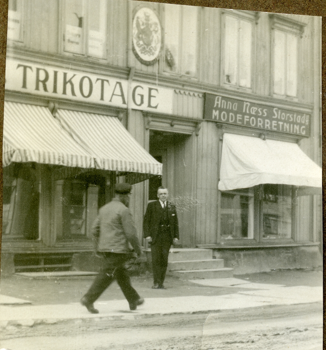 2 menn utenfor klesforretning, muligens i Tromsø? Album etter Carl S. Sæther