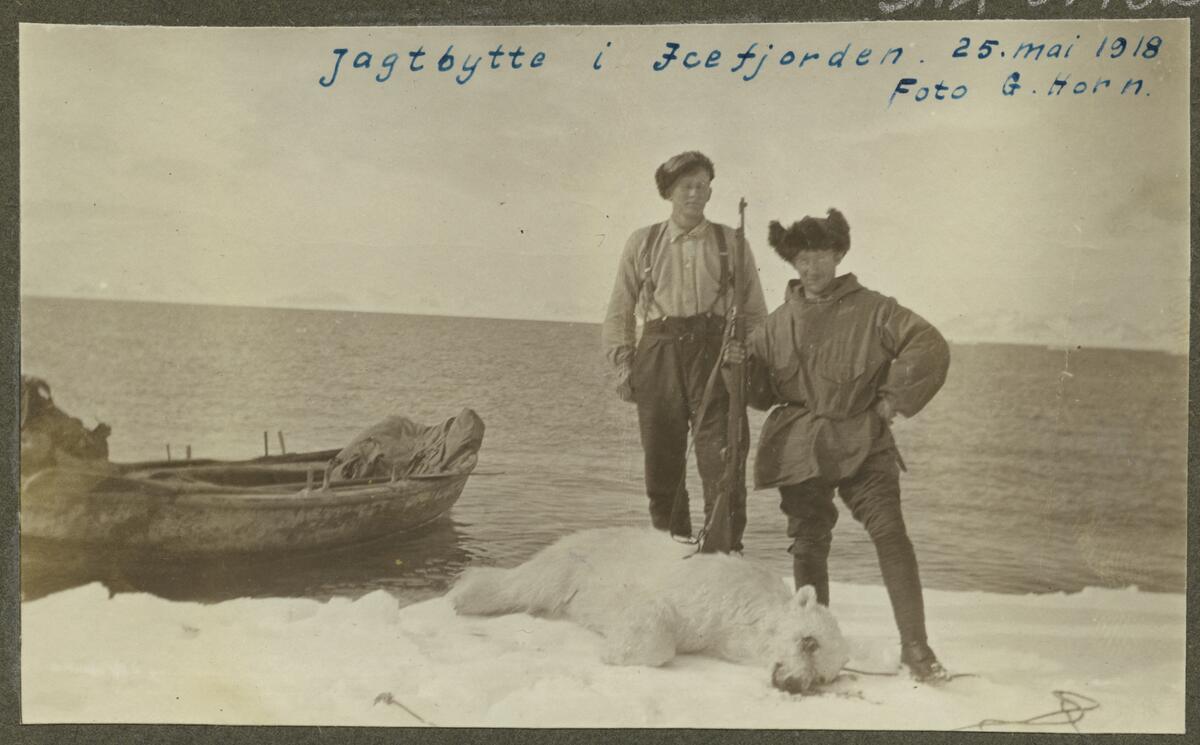 Isbjørnjakt i Isfjorden. 2 menn, båt. Privat album, eier ukjent (trolig Gunnar Horn).