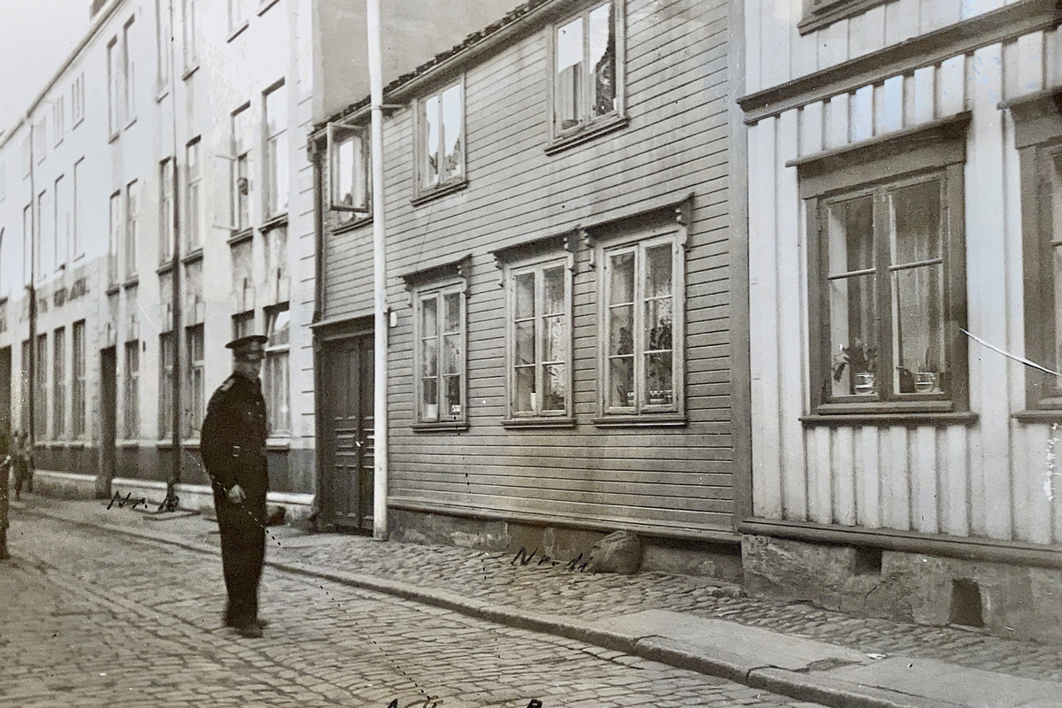 Montasje med fire foto, tekst og bevisgjenstander; revolver, deformerte prosjektiler og trebit. Rammen og revolveren er fjernet.