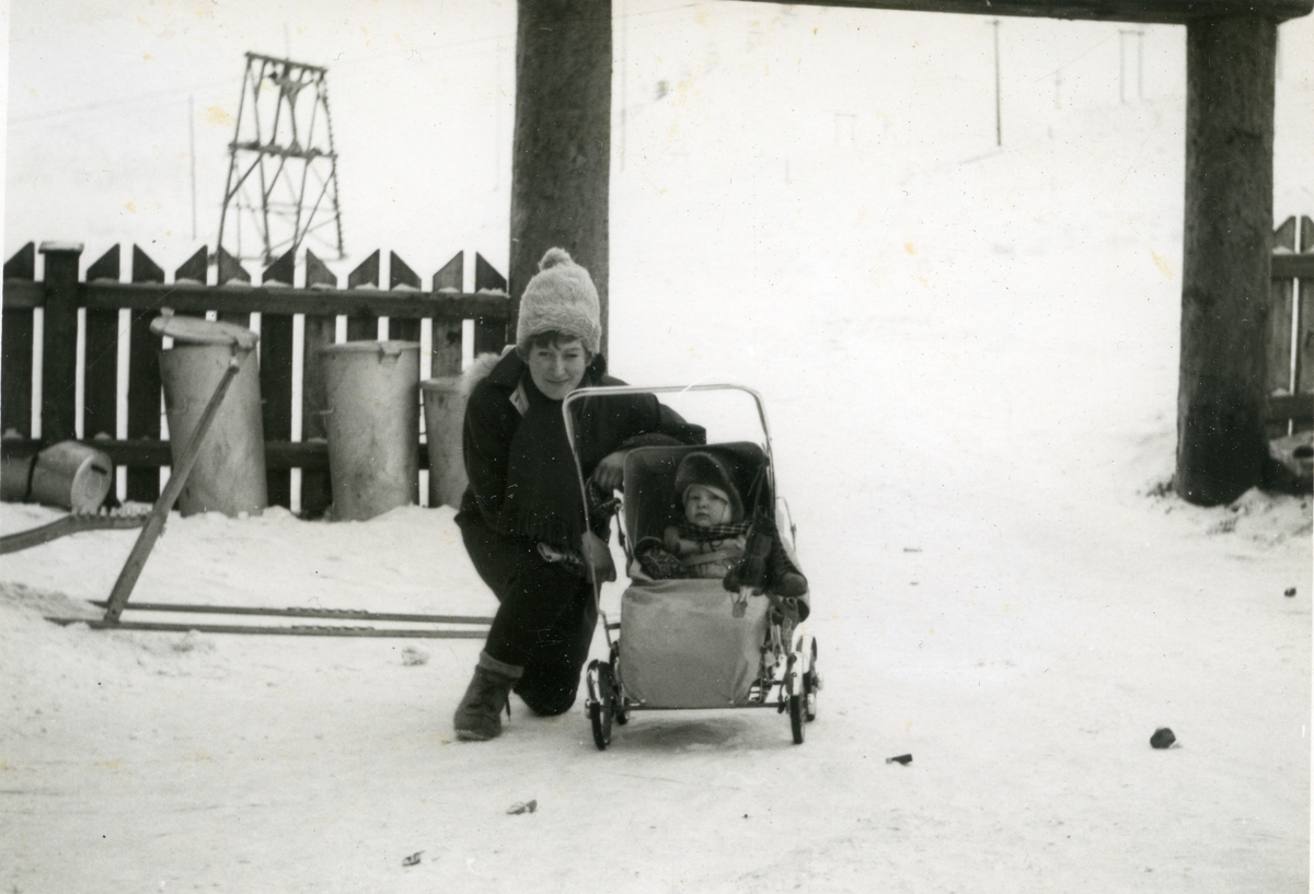 Sigrid Skeiseide med Svein Midbøe i barnevogn i Sysselmannsgården vinteren 1963.