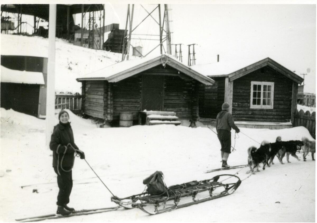 Lorraine og Finn B. Midbøe med hundespann og slede utenfor Sysselmannsgården påsken 1963.