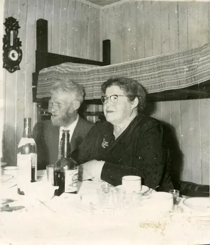 Helfrid og Hilmar Nøis feirer sølvbryllup på Fredheim i Sassen våren 1963. Den egentlige dagen var 22.august 1962. Sigrid Skeiseide, som har tatt bildet, forteller: Hilmar Nøis og konen feiret Sølvbryllup i 1963, og Sysselmannen tok med seg alle de fra regjeringen og andre departementer som kom opp  angående Ny-Ålesund-ulykken. Jeg fikk være med, siden det var jeg som hadde bakt kake til dem. Det å få møte Hilmar Nøis og konen, og å få sitte og høre dem fortelle om livet i Sassen og på Svalbard, er fremdeles en av mine store opplevelser. Sigrid Skeiseide var hushjelp hos sysselmann Finn Backer Midbøes familie vinteren 1962-63.