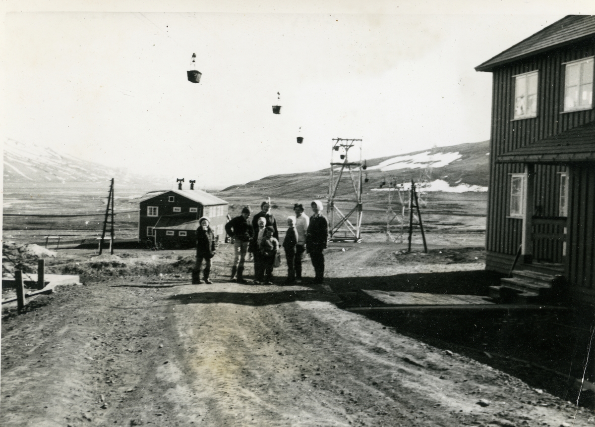 Barn og voksne på veien utenfor Telegrafen på Skjæringa våren 1963. Rødhuset i bakgrunnen. Taubanetraseen til Gruve 5.