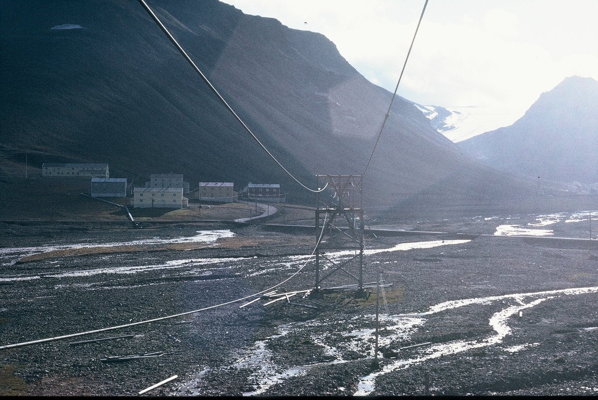 Bebyggelsen på Haugen sett fra Skjæringa. Store Norske engasjerte roverspeidere til ryddearbeid i Longyearbyen for første gang 1974. To grupper reiste oppover med 6 personer i hver gruppe, og gruppene overlappet hverandre i løpet av sommeren. Avtalen gikk ut på at reise, kost og losji ble dekket av Store Norske, det skulle arbeides i 4 uker med kr.20 som lommepenger til hver per dag, og de skulle få en uke ferie på slutten av oppholdet til turaktivitet. Som turglade og noe spenningssøkende ungdommer var dette sett på som et utrolig flott tilbud og ble meget populært. Store Norske engasjerte roverspeidere til slikt ryddeprosjektet fikk Store Norske fra det nyetablerte Miljødepartementet som sommeren 1973 engasjerte roverspeidere til oppryddningsarbeid etter gruvedriften i den gang meget tynt bebodde og noe forfalne Ny-Ålesund. At ryddeprosjektets ide fortsatt lever viser Sysselmannsetatens årlige ryddetokt langs Svalbards strender, og interessen for å være med er stor.