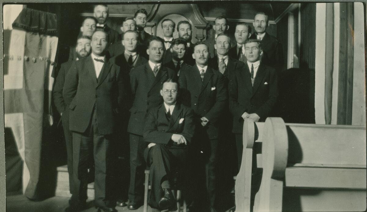 Forsamling av mennesker, og flagg i Vår Frelsers Kirke på Spitsbergen Bildet er del av fotoalbum: SVB 2668 Louis Torjusen arbeidet på lageret og var også organist i kirken samt dirigent for mannskoret i 3 år fra 1924