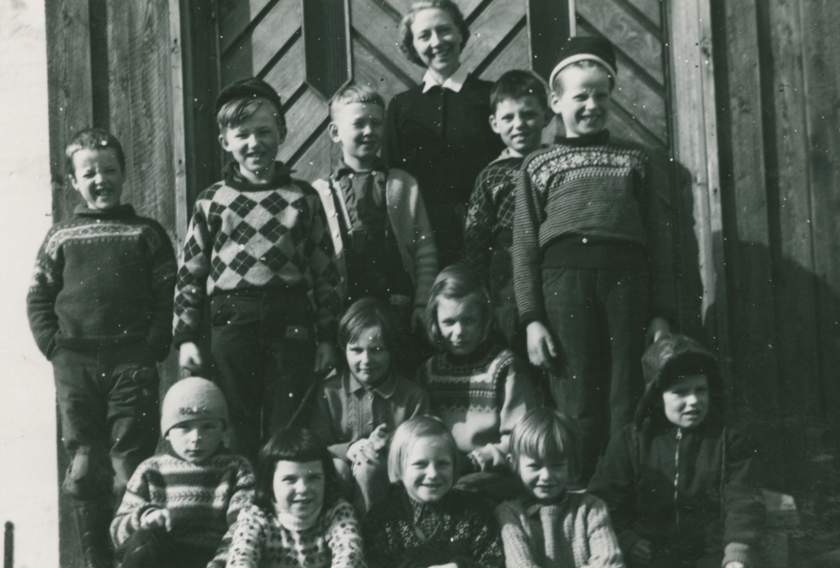 2.klasse på skoletrappa våren 1960. Foran fra venstre: Geir Paulsen, Tone Nødtvedt, Sylvi Tollefsen, Bodil Pettersen og Anders Rugaas. I midten: Anne Lise Rubach og Bodil Langbakk. Bak: Jack Askvik, Kurt Skog, Wilhelm Gjevestad, lærer Arnhild Øyen, Bjørn Andersen og Ole Robøle.