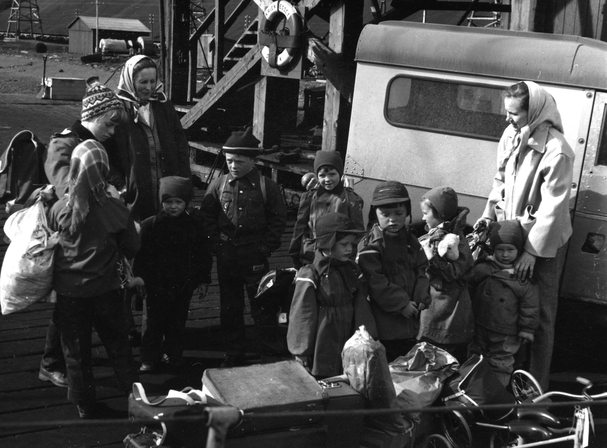 Ankomst med D/S Ingerto fra Norge til  Svalbard i  august 1957. Familiene Andersen, Nødtvedt og Torgersrud. Fra venstre: Britt Andersen, Solveig Nødtvedt, Ranveig Nødtvedt, Randi Nødtvedt, Eigil Nødtvedt, Tone Nødtvedt, Bernhard Andersen, Bjørn Johan Andersen, Laila Torgersrud, Hans Torgersrud og Astrid Torgersrud.