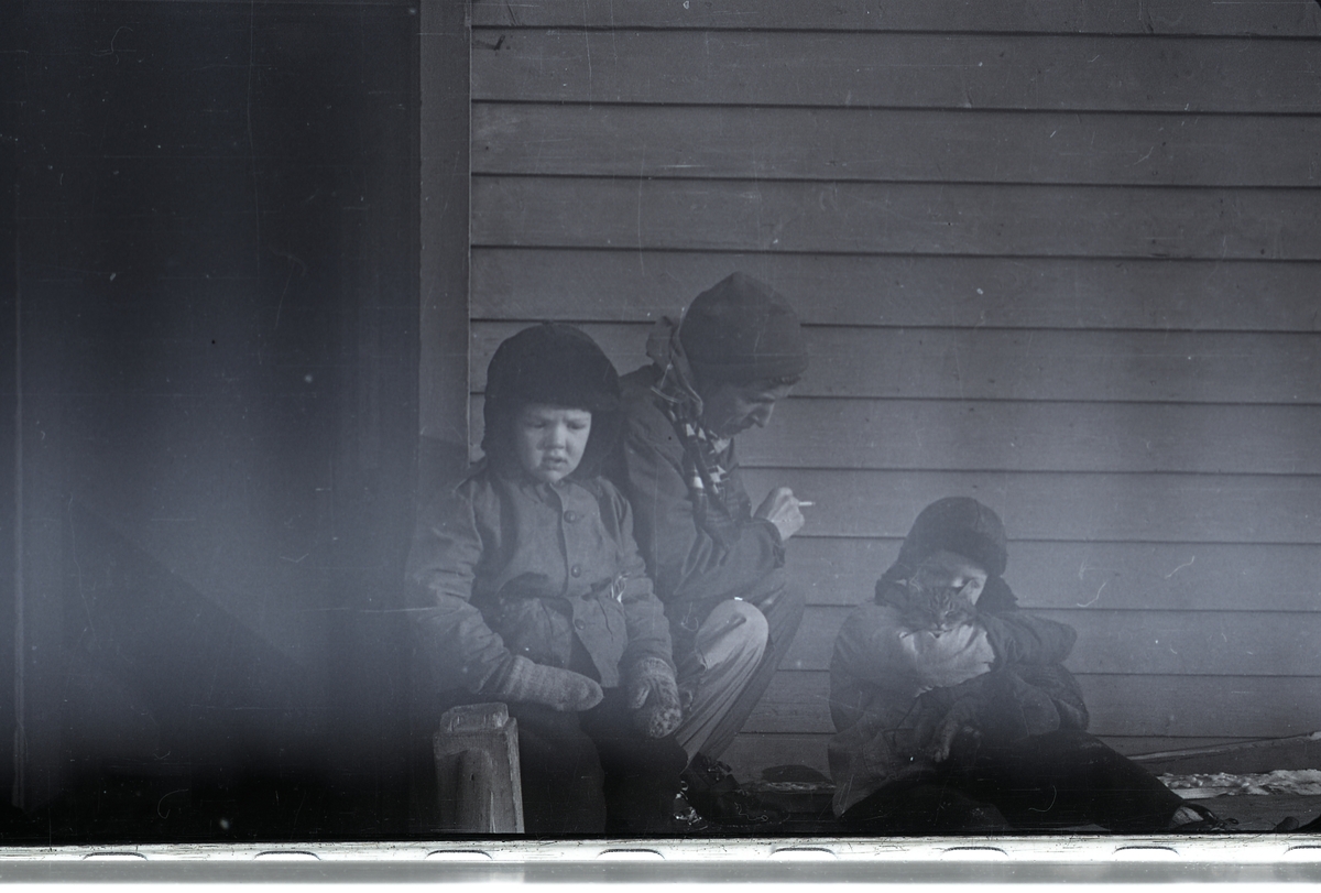 Terje, Margit og Jack Askvik med katt utenfor huset på Haugen i mars/april 1958.