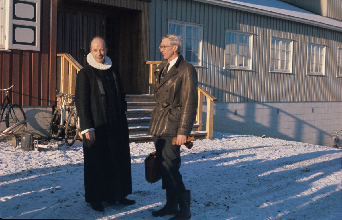 Sokneprest Erling J. Nødtvedt  og skolestyrer Zelow Ullring foran Svalbard kirke vinteren 1960