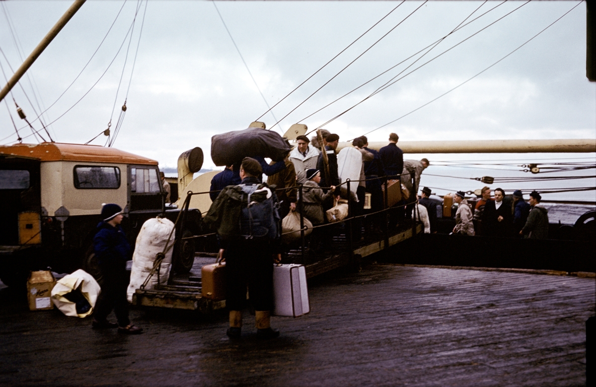 Kjødebåten Ingerfem har ankommet Gamlekaia 1.juli 1960 med gjester til konfirmasjonen 3.juli. Her er de som skal reise ned i ferd med å gå ombord.