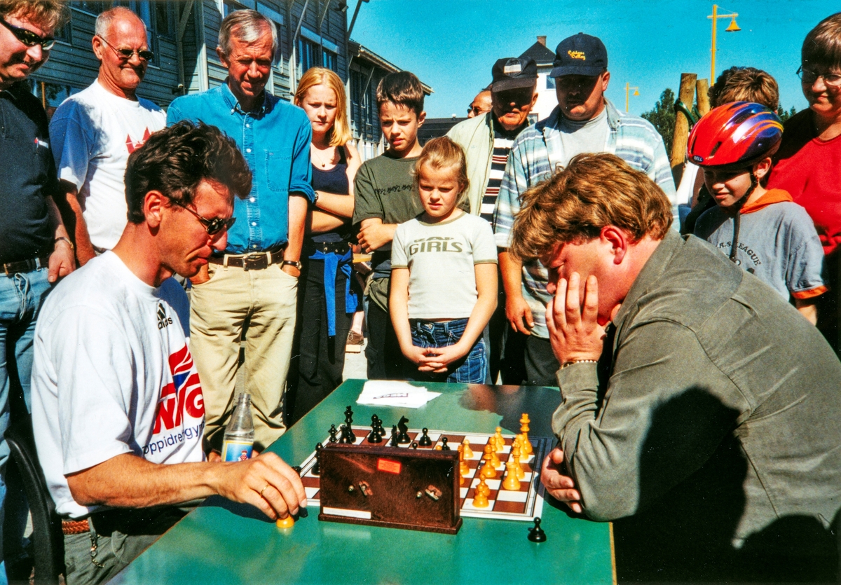 Simultansjakk i Løten sentrum i forbindelse med Løten Sjakklubb sitt 70 års jubileum i 2000. Til venstre, med mørke sjakkbrikker, Simen Agdestein. Han vant 30 av sine sjakkpartier denne dagen, bare slått av Per Christian Stenvaag, her med lyse sjakk brikker. Per Chritian Stenvaag var da formann i Løten Sjakklubb.