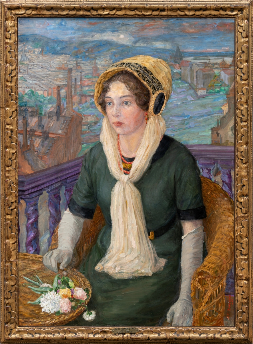 Forfatteren Sigrid Undset sittende i en kurvstol på en altan med utsikt over Kristiania.