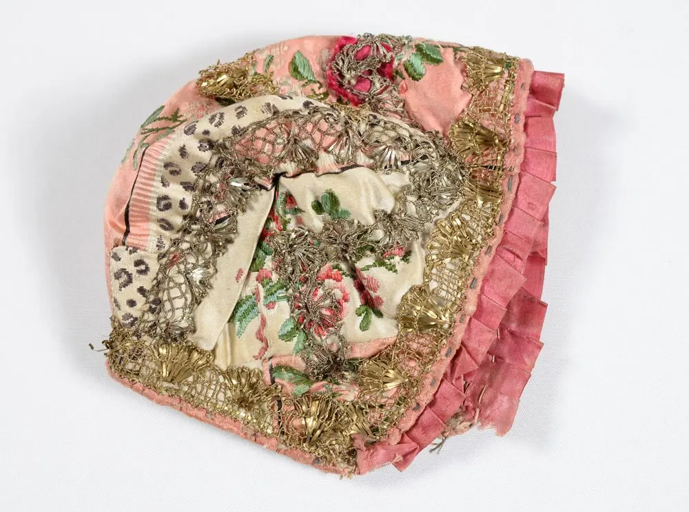 Dåpslue i rosamønstrete silke med sølvkniplinger fra Gudbrandsdalen.