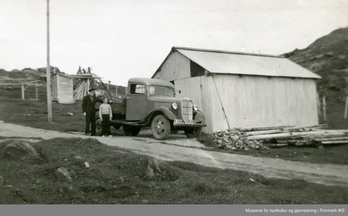 Honningsvåg, Storbukt. En mann og en ung gutt foran et skur, ved siden av en Ford V8 lastebil (årsmodell 1936) med registrering Y-129.