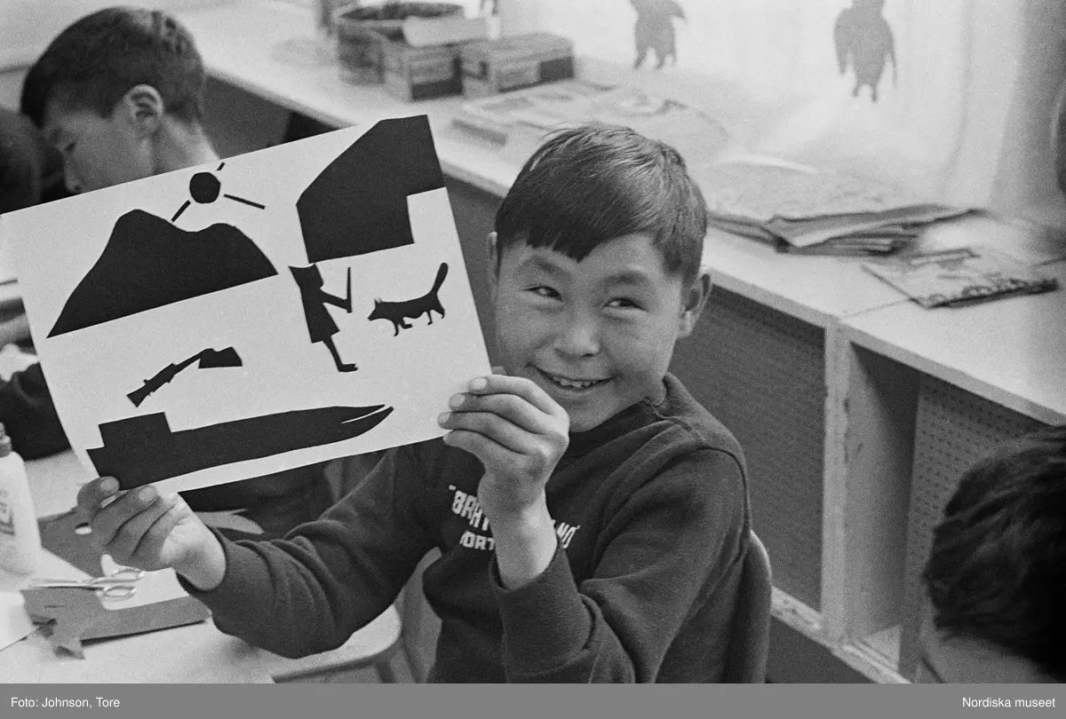 Arktis. Lappland. En flicka gör en teckning i skolan. En pojke håller en teckning.