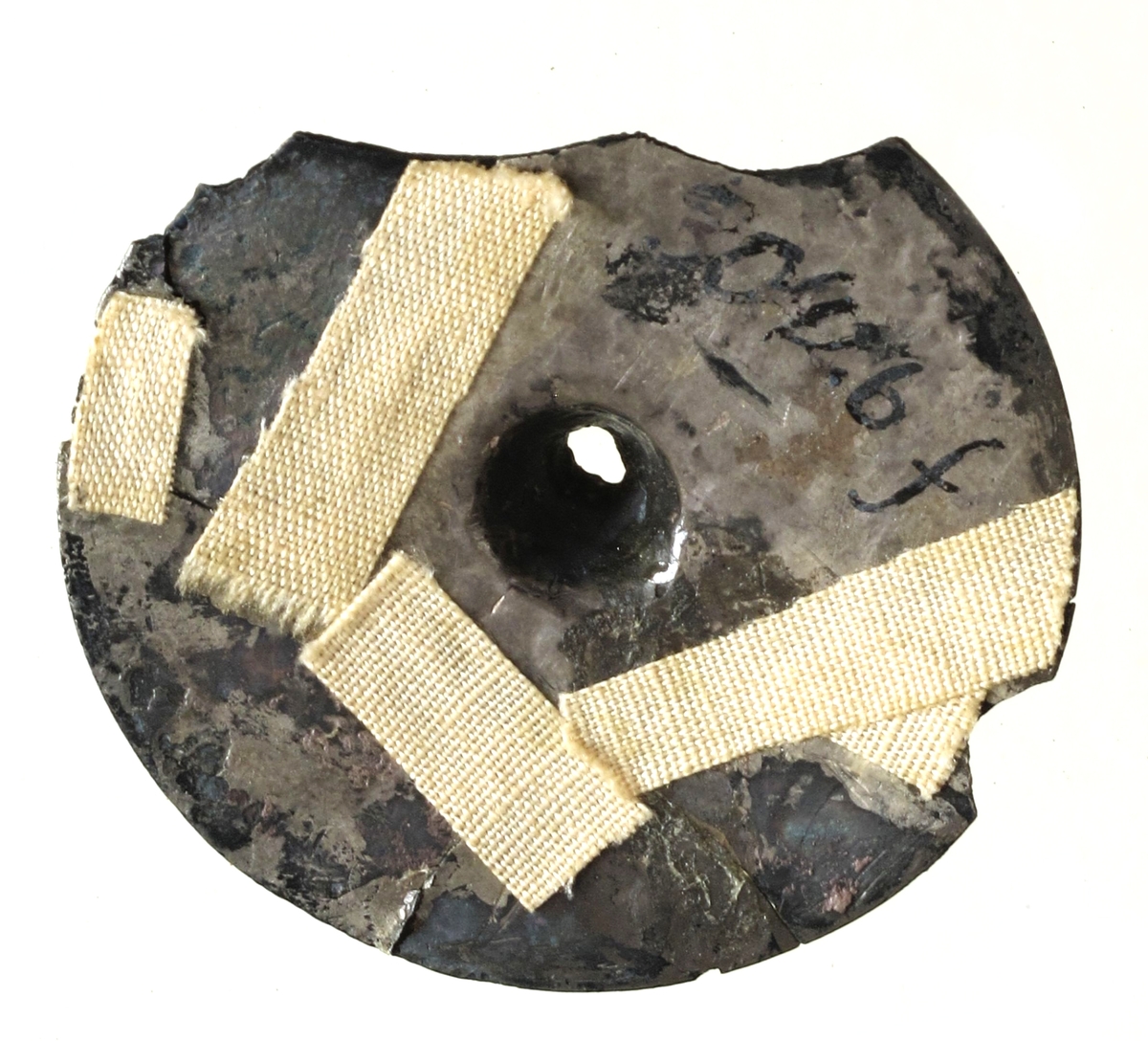 Sirkelrund plate med konisk midtknopp av forgylt sølv av typen [Rygh fig.310]R. 310. Stykket er ornert med konsentriske felter med punsel- og stempelornering, nemlig en dobbelt rad trekanter, så en rekke med små punkter, en tredobbelt rad med noe større punkter og halvmåner på hver side begrenset av en småstiplet linje. Midtstykket er omgitt av en rad sterkt tilspissete trekanter ved hvis toppunkter det finnes små halvmåner. Den ytre begrensning er her en rad små punkter. Stykkets kant er glatt. Foreligger i 5 sammenhørende deler. Noe av kanten mangler. 
