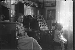 Kvinne og barn sittende i stue med øreklokker på hodet. Det 