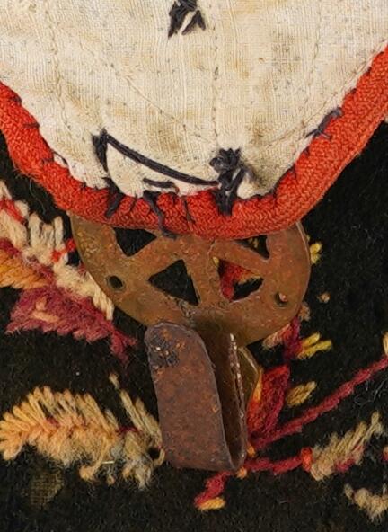 Blomeranke brodert på, sekstakka stjerne eller blome i massingkrok.
