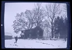 Person ståendes på en snötäckt gård.