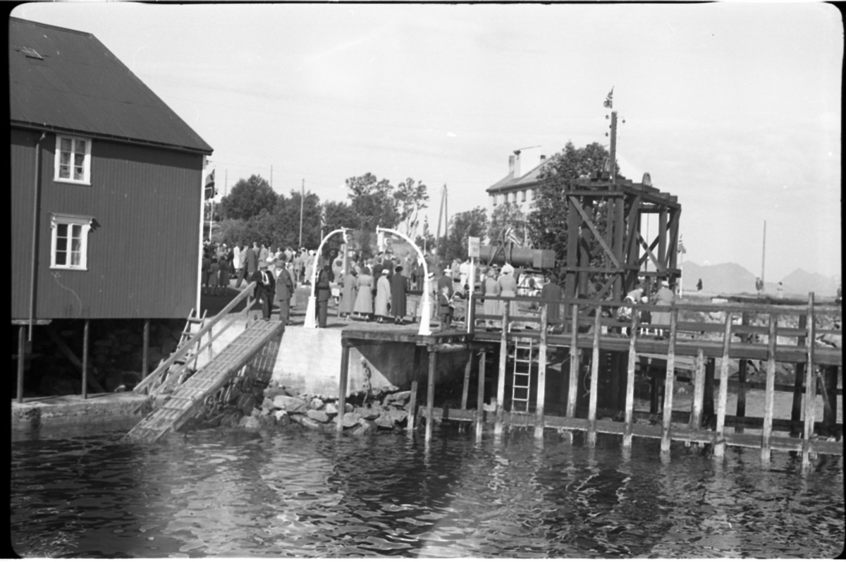 Fra kongebesøket på Stokmarknes 1959. Folkeliv ved Rødbrygga. VDS-bygget i bakgrunnen