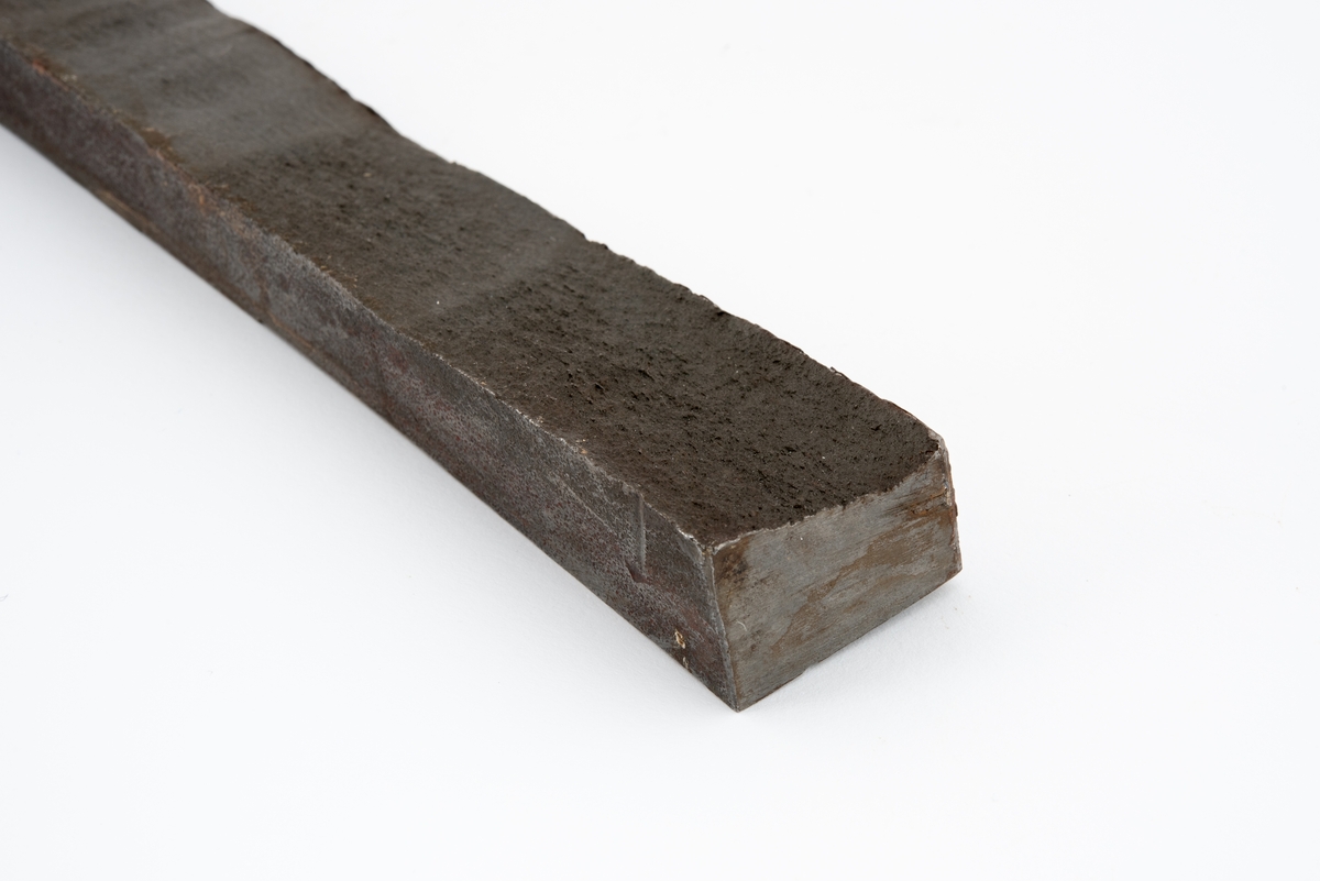 Metallprøve skåret ut fra bruddflate til stagdel fra D6 staget på riggen Alexander L. Kielland. 

Prøven viser regelmessige linjer "rastlinjer" i bruddflaten, og viser at sprekkens gradvise utvikling har medført at det har dannet seg et mønster i bruddflaten som kan sammenlignes med årringer i et tre. Slike linjer er typisk ved utmattingsbrudd og viser at metallet har gitt etter over tid. 

Den siden av prøvestykket som tilsvarer stagveggens utside er fremdeles dekket med maling.

Metallstykket har påført merking i gult og blått, og bokstaver og tall er risset inn i materialet. Det er sannsynlig at noe av denne informasjonen henviser til stagdel og avstand i centimeter fra initieringspunkt A for utmattingsbrudd. 

I noen tilfeller omtales initieringspunkt A som initieringspunkt I.