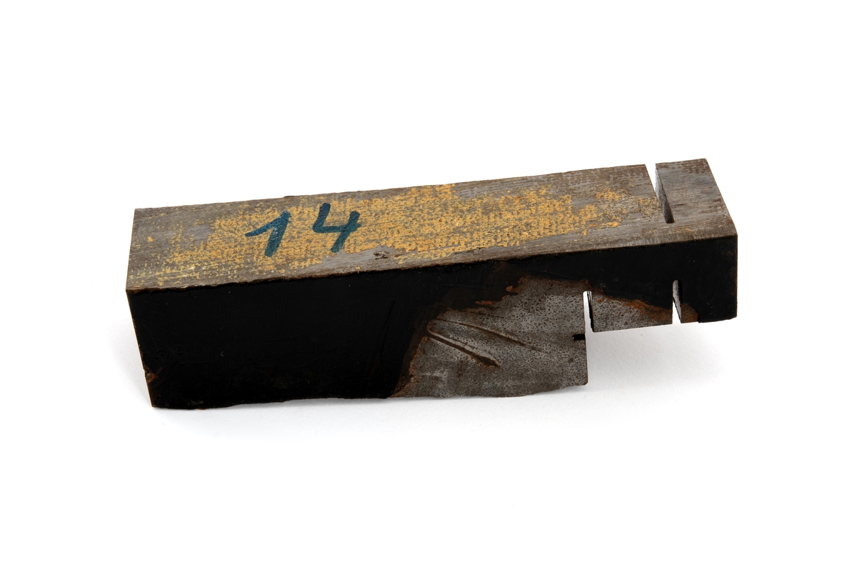 Metallprøve skåret ut fra bruddflate til stagdel fra D6 staget på riggen Alexander L. Kielland. 

Prøven viser regelmessige linjer "rastlinjer" i bruddflaten, og viser at sprekkens gradvise utvikling har medført at det har dannet seg et mønster i bruddflaten som kan sammenlignes med årringer i et tre. Slike linjer er typisk ved utmattingsbrudd og viser at metallet har gitt etter over tid. 

De to sidene av prøvestykket som tilsvarer stagveggens innside og utside er fremdeles delvis dekket med sort maling. 

Bokstaver og tall er stiplet inn i metallstykkets overflate. Det er sannsynlig at det ene av disse tallene henviser til avstand i centimeter fra initieringspunkt A for utmattingsbrudd. I dette metallstykket er tallet 770 risset inn som betyr at stykket sannsynligvis er skåret ut fra bruddflaten nærmere initeringspunkt B. 

I noen tilfeller omtales initieringspunktene A pg B som I og II.