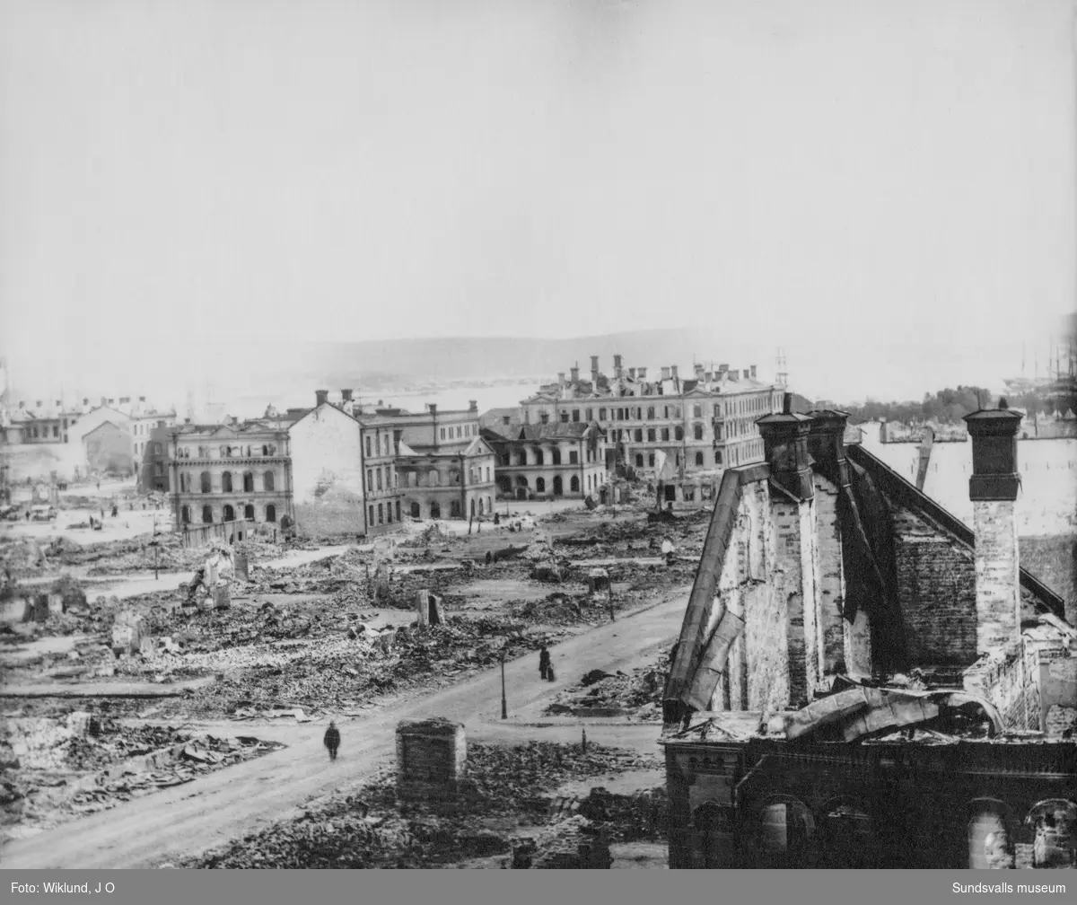 Sundsvalls stadsbrand 1888.  I förgrunden den brandskadade Betlehemskyrkan, senare Frimurarlogens hus. De byggnader som kvarstår är till vänster Stadshuset och Bankhuset och till höger Schack- och Läsesällskapets hus (W6).