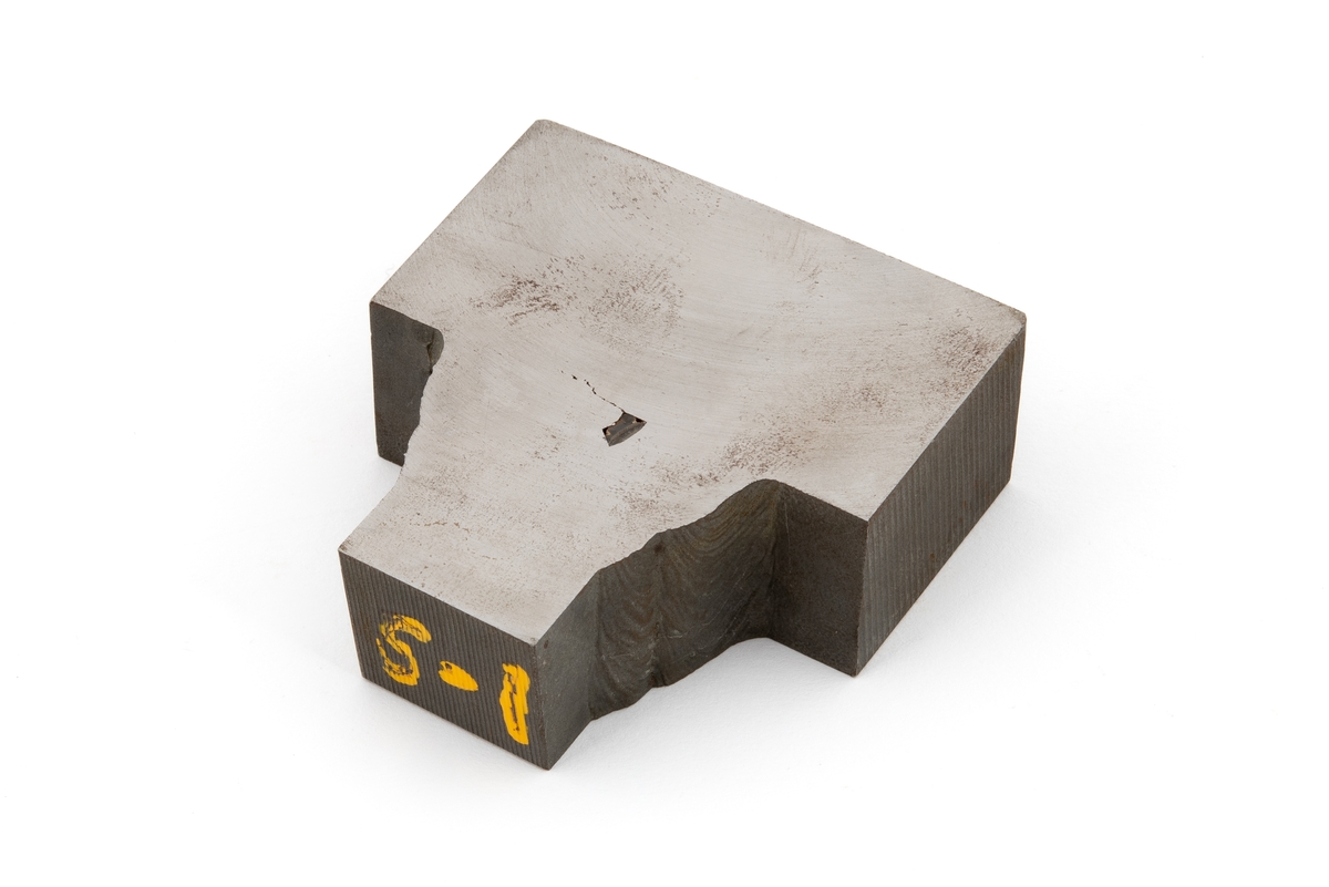 Metallprøve som er merket S-1. Prøven inneholder to sveiser som er gjennomskåret, og det er sannsynlig at dette er et prøvestykke som ble skåret ut fra påsveiset forsterkning rundt drenshullet til stag D6. 

Overflaten ble polert for å gjøre det mulig å kunne se strukturen i metallet ved undersøkelse i mikroskop.
