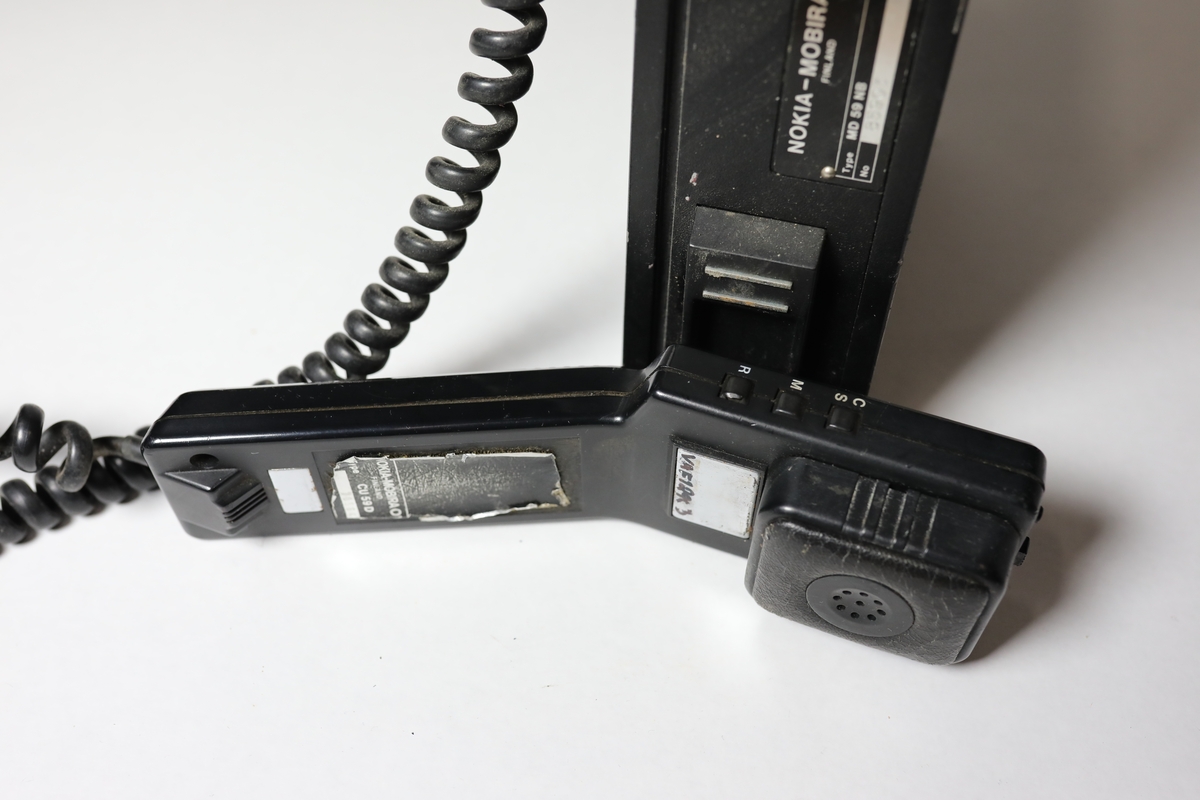 rektangulær eskeform m/håndtak og telefonrør m/ knaster og høytaler. Hektet på v hjelp av ssterk magnetplate antenne på håndtaket.