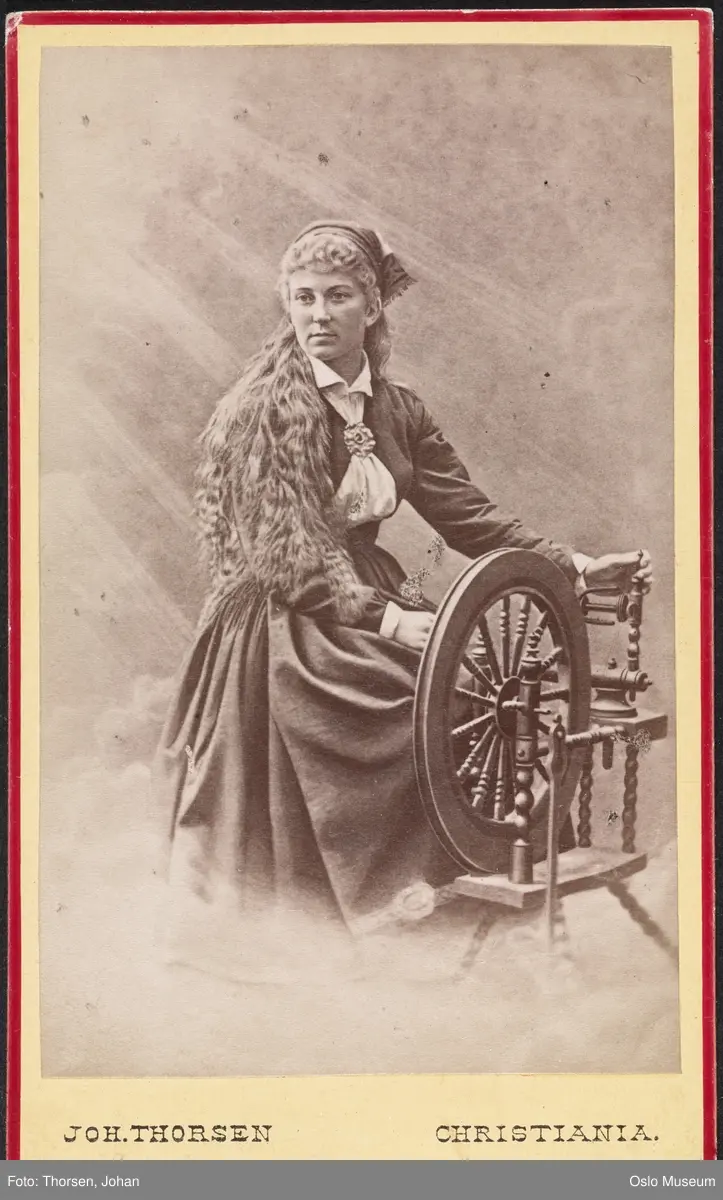portrett, kvinne, skuespillerinne, rollebilde, Solveig i "Peer Gynt" ved uroppførelsen på Christiania Theater, sittende helfigur ved rokk, kostyme