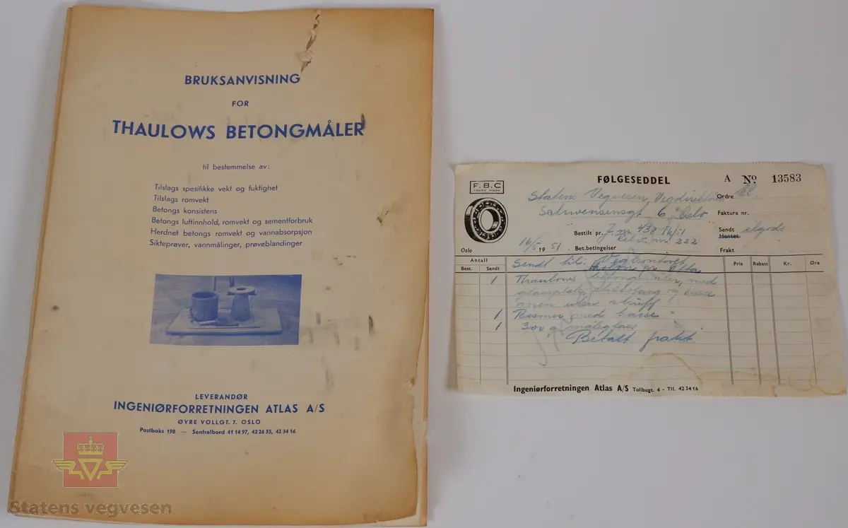 Ei trakt og et 10 liters målekar i aluminium. Ei glassplate samt bruksanvisninger i ei malt trekasse. Delene er kontrollmåler, trakt og 10 liters målekar. I lokket er det et rom for medfølgende glassplate.
