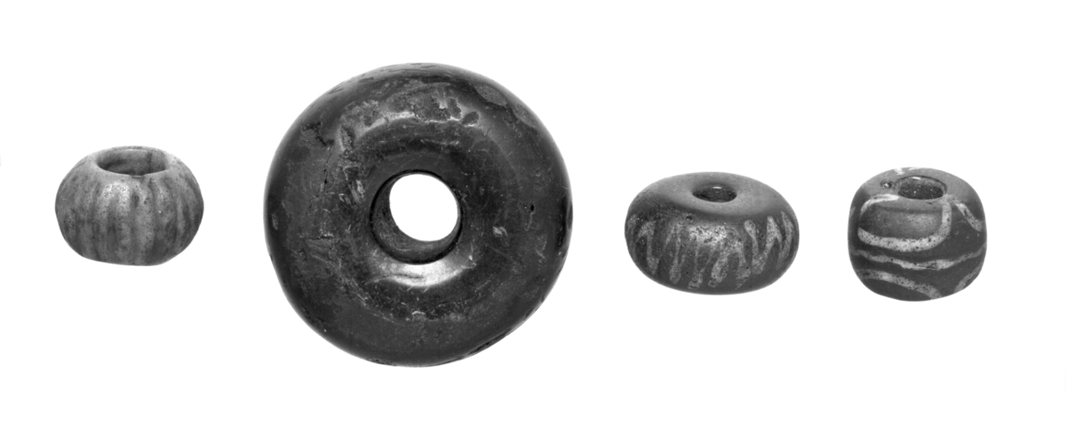 Hovedkatalogen: "c) en blaagrøn do. med horizontalt riflet Side og meget stort Hul; vel 5/8 Tom. i Gjennemsnit paa Midten, hvorfra den bøier af mod Hullet, der er 5/16 Tom.[0,8 cm] i Gjennemsnit." 