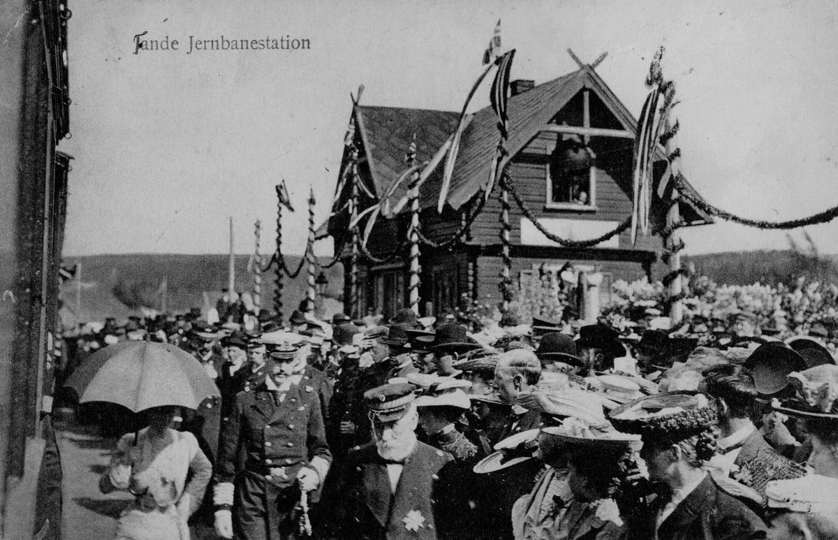 Postkort, Ringsaker, stor folkemengde hilser kong Haakon og dronning Maud velkommen ved Tande stasjon, Ringsaker stasjon. Kroningsreisen til Trondheim den 13. juni 1906, første dag på reisen,