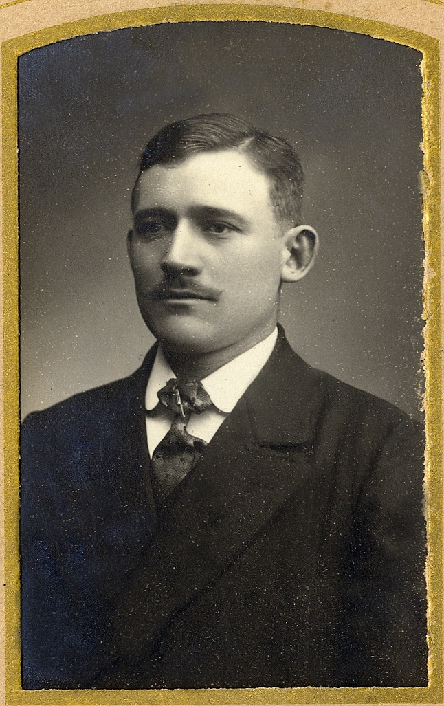 En man i mörk kostym med stärkkrage och slips.
Under fotot text med blyerts: "Knut Engstrand", 
Bröstbild, halvprofil. Ateljéfoto.