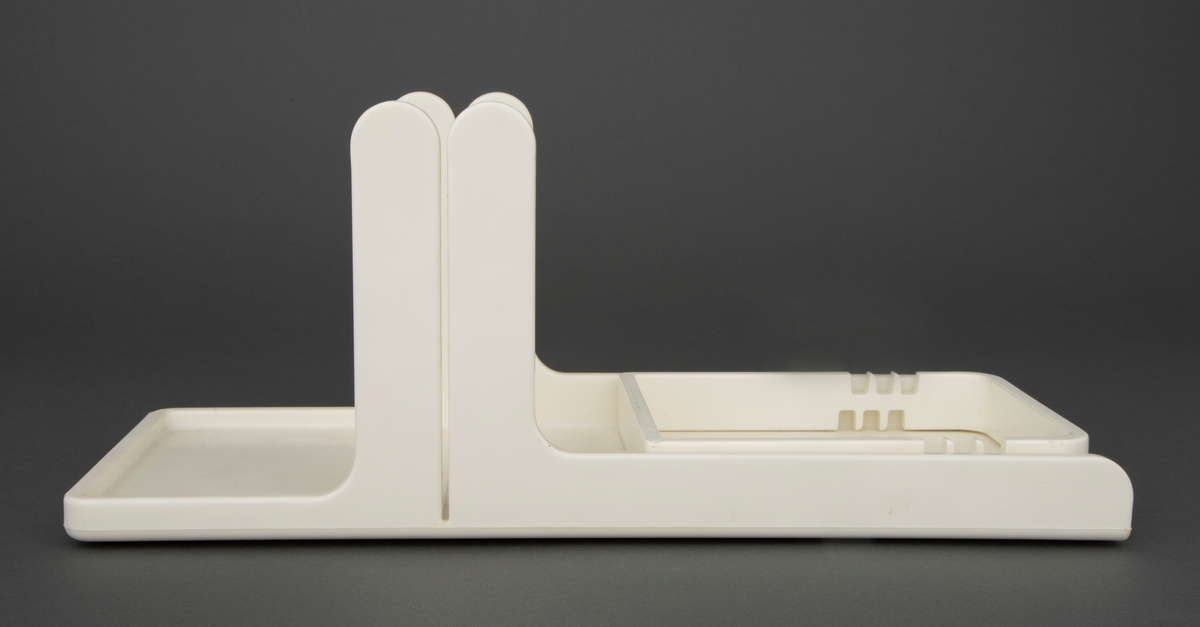 Skjærebrett som består av et støttebrett og en løs innsettingsramme, alt i hvit propenplast. Brettet har lave støttekanter og tvers over er det en slisse der knivene føres ved skjæring. Den løse rammen har seks par utsparinger som passer i brettets endekant og regulerer avstanden til skjæreslissen. På brettets underside er det seks små, grå plastklosser som hindrer brettet å gli.